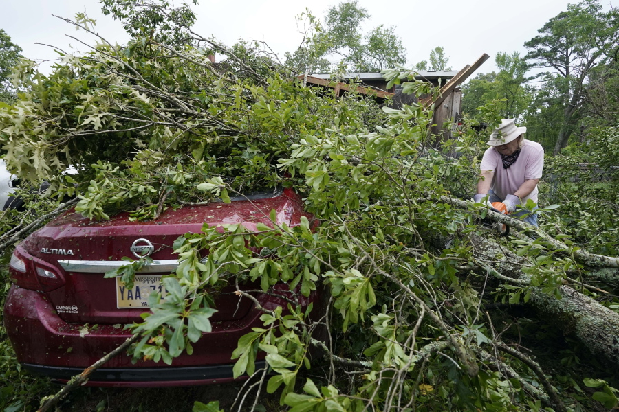 FILE - Span McGinty uses his chain saw to cut fallen tree limbs from a tornado-damaged vehicle at his brother's house in Yazoo County, Miss., on May 3, 2021. 90% of counties in the United States experienced a weather-related disaster between 2011-2021, according to a report published on Wednesday, Nov. 16, 2022. Over 300 million people -- 93% of the country's population -- live in those counties. (AP Photo/Rogelio V.