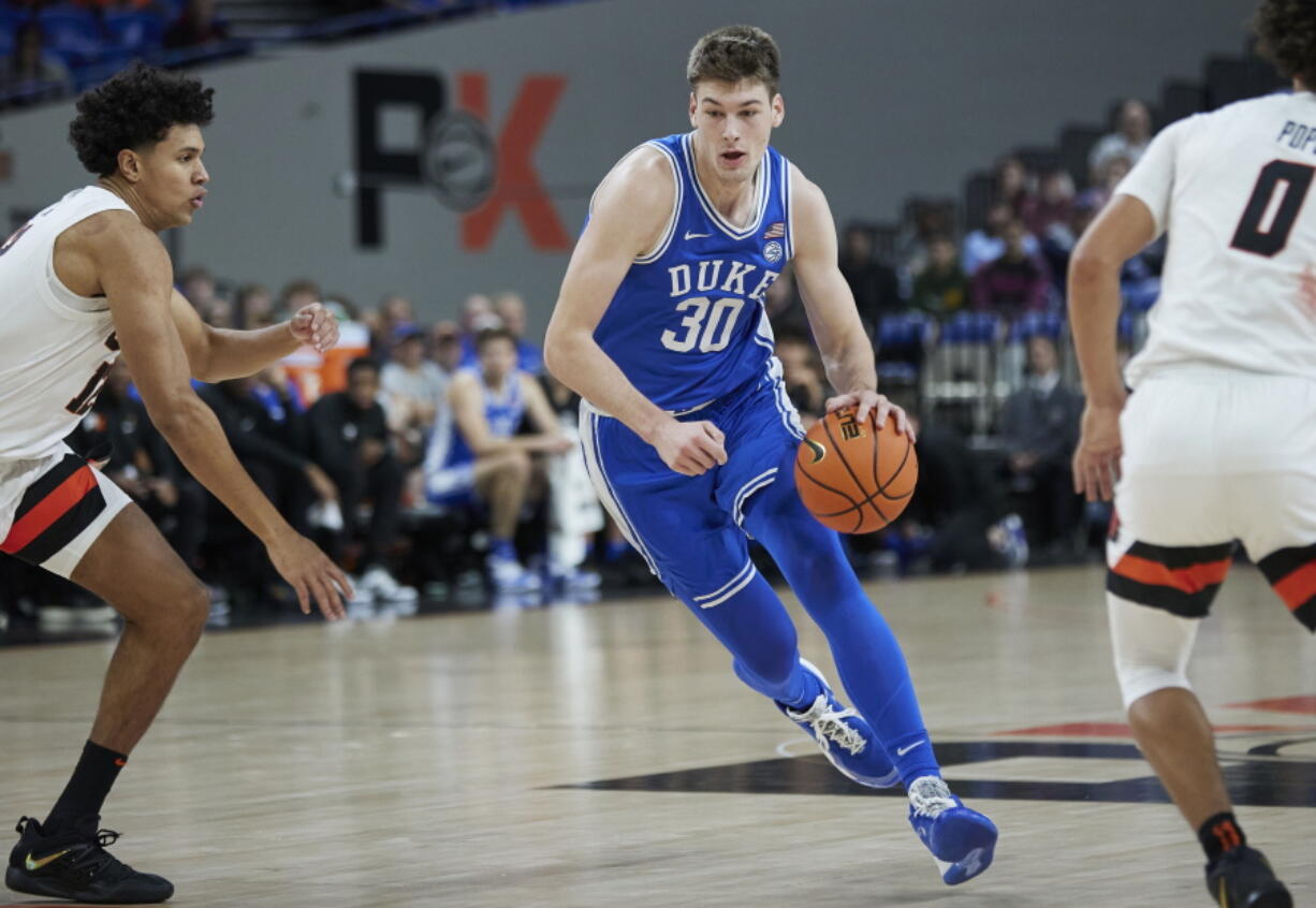 Duke center Kyle Filipowski, right, dribbles towards Oregon State forward Michael Rataj during the first half of an NCAA college basketball game in the Phil Knight Legacy tournament in Portland, Ore., Thursday, Nov. 24, 2022.