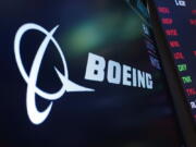 FILE - The logo for Boeing appears on a screen above a trading post on the floor of the New York Stock Exchange, Tuesday, July 13, 2021. Boeing reported a $3.3 billion loss for the third quarter Wednesday, Oct. 26, 2022, as revenue fell short of expectations, it took a huge losses for fixed-cost defense programs and its commercial-airplane business struggled.