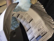 Ballots are prepared to be sent through a scanner on Election Day at the King County Elections headquarters, Tuesday, Nov. 8, 2022, in Renton, Wash.