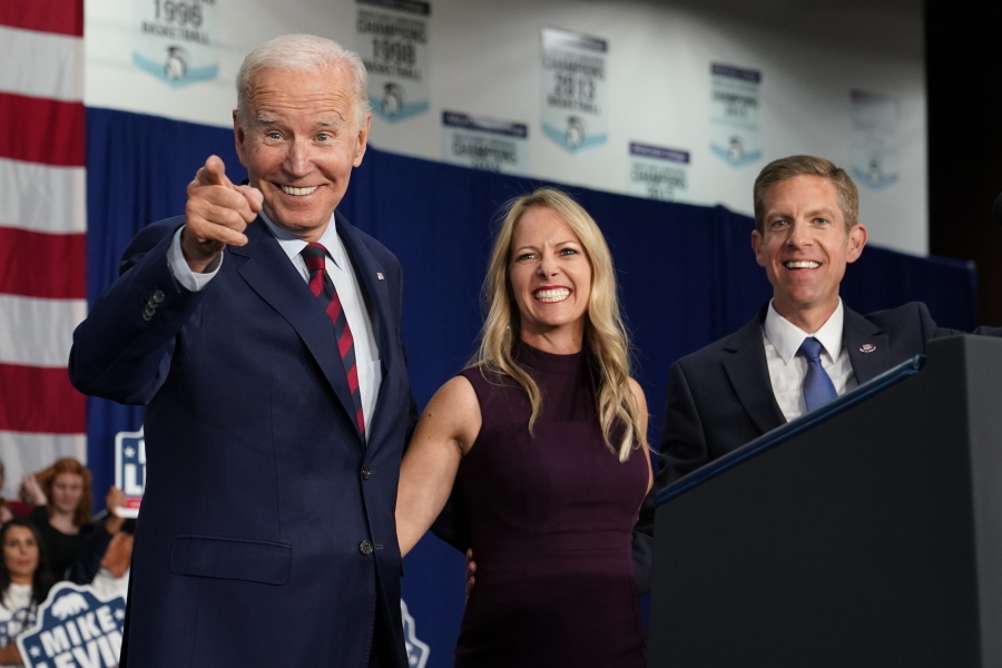 President Joe Biden stands on stage with Rep. Mike Levin, D-Calif., and his wife Chrissy, after Biden spoke at a campaign rally Thursday, Nov. 3, 2022, in San Diego.