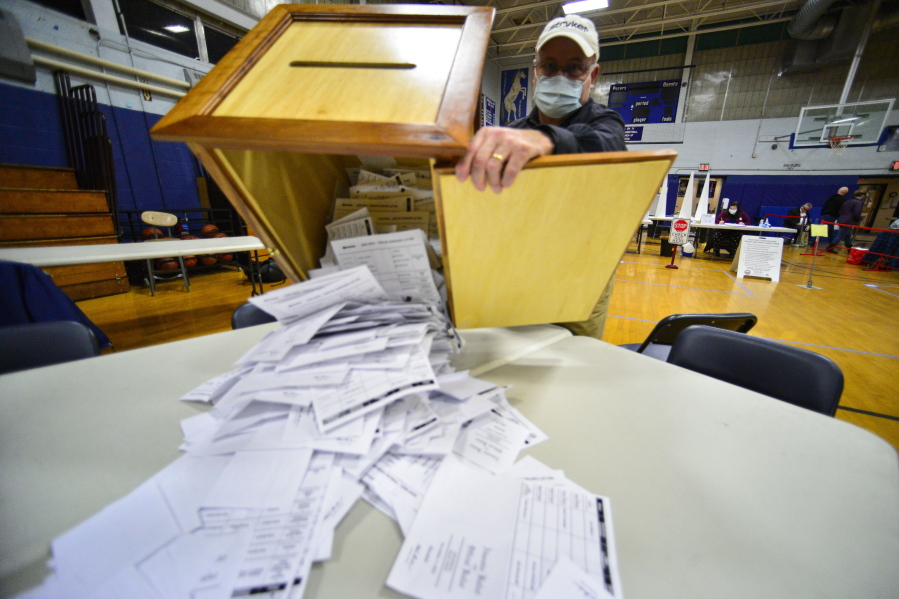 FILE - Steve Diorio, the Chair of the Hinsdale, N.H., Select Board, dumps out nearly 1900 ballots onto a table to be hand-counted at the Hinsdale Middle High School on Nov. 3, 2020 in Hinsdale, N.H. Election experts oppose hand-counting ballots because it takes longer than counting with machines, it's less reliable and it's a logistical nightmare for U.S. elections.
