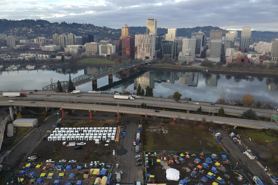 FILE - In this aerial photo taken with a drone, tents housing people experiencing homelessness are set up on a vacant parking lot in Portland, Ore., on Dec. 8, 2020. Voters in Portland, Ore., have approved a ballot measure that would completely overhaul City Hall, amid growing public frustrations over homelessness and crime. The measure will scrap the city's unusual commission form of government and replace it with a more traditional city council.