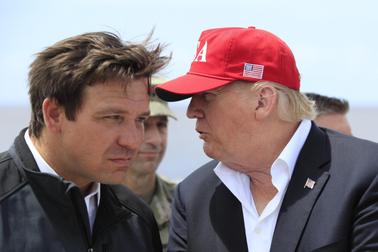 FILE - President Donald Trump talks to Florida Gov. Ron DeSantis, left, during a visit to Lake Okeechobee and Herbert Hoover Dike at Canal Point, Fla., March 29, 2019. Republican 2024 presidential prospects descend upon Las Vegas this weekend as anxious donors and activists openly consider whether to embrace former President Donald Trump for a third consecutive run for president. Trump will be among the only major Republican prospects not in attendance for the Republican Jewish Coalition'??s annual leadership meeting.