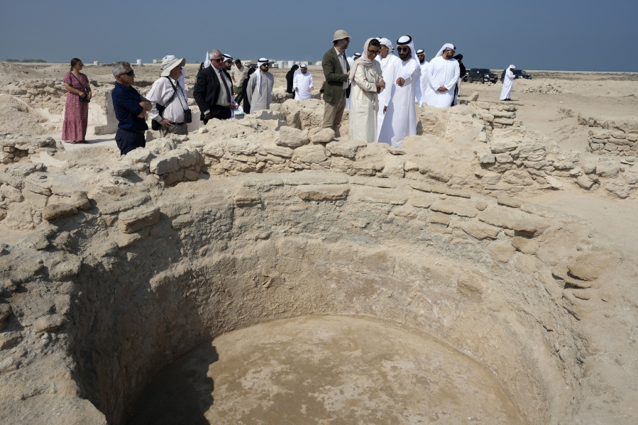 Sheikh Majid bin Saud Al Mualla, chairman of the Umm al-Quwain Department of Tourism and Archaeology, front right, speaks during a tour of the site of an ancient Christian monastery Thursday on Siniyah Island in Umm al-Quwain, United Arab Emirates.