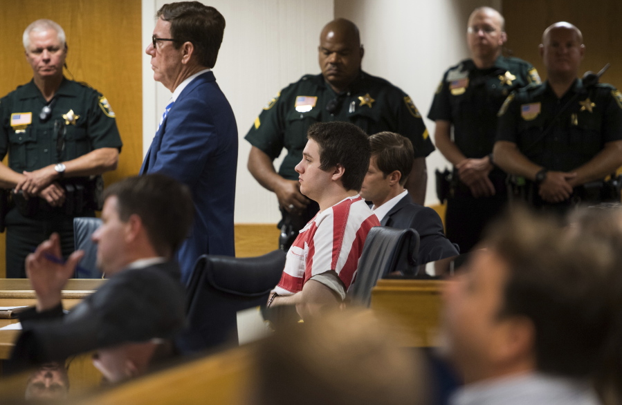 FILE - Austin Harrouff, center, wearing stripes, accused of brutally killing a Tequesta couple in 2016, appears Friday, Aug. 2, 2019, at the Martin County Courthouse in Stuart, Fla., as defense attorney Robert Watson, standing in front of Harrouff, asks Martin County Circuit Judge Sherwood Bauer Jr., to not allow video recording of a mental health evaluation to be conducted by a psychologist hired by the state. Harrouff, a former college student who killed a Florida couple in their garage six years earlier and then chewed on one victim's face, is finally set to go on trial, Monday, Nov. 21, 2022.