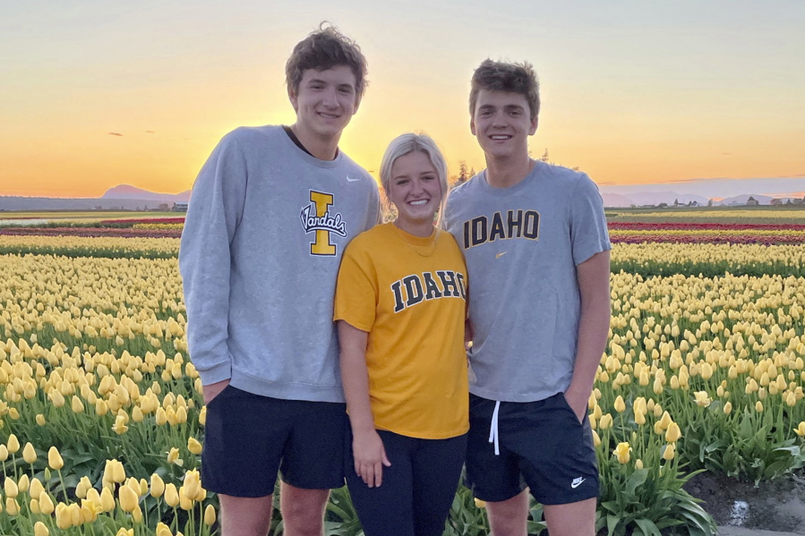 In this photo provided by Stacy Chapin, triplets Ethan, Maizie and Hunter Chapin pose in front of a tulip field in La Conner, Wash., in April of 2021. Ethan Chapin was one of four University of Idaho students found stabbed to death in a home near the Moscow, Idaho campus on Sunday, Nov. 13, 2022. Police are still searching for a suspect in the case.