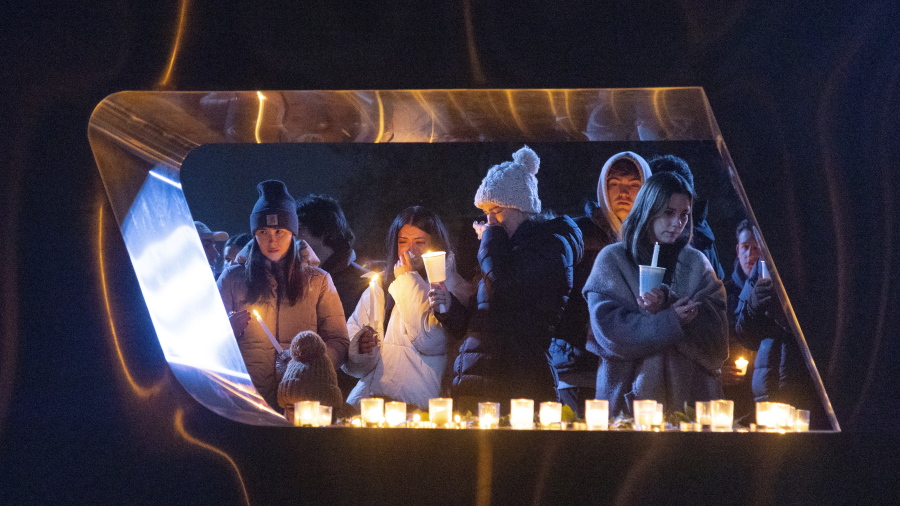 Boise State University students, along with people who knew the four University of Idaho students who were found killed in Moscow, Idaho, days earlier, pay their respects at a vigil held in front of a statue on the Boise State campus, Thursday, Nov. 17, 2022, in Boise, Idaho. Autopsies performed on the four students who were found dead inside a rental house near campus showed that all four were stabbed to death, the Latah County coroner said. (Sarah A.