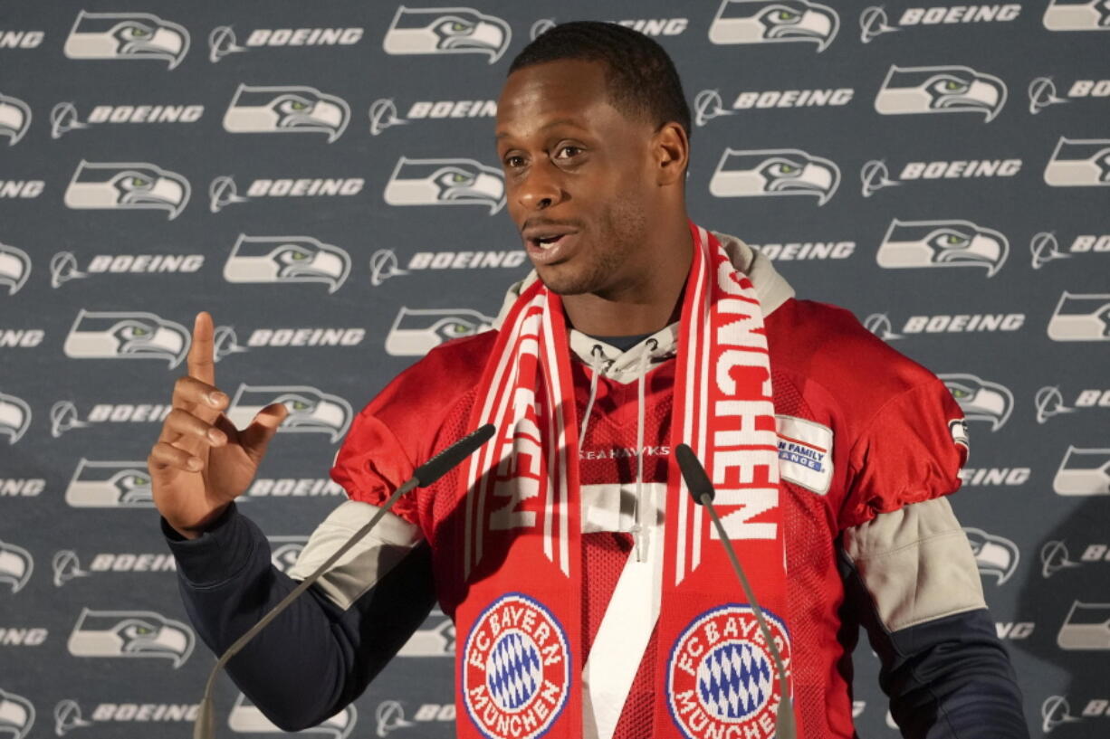 Seattle Seahawks quarterback Geno Smith wears a FC Bayern Munich scarf as he answers questions during a news conference after a practice session in Munich, Germany, Thursday, Nov. 10, 2022. The Tampa Bay Buccaneers are set to play the Seattle Seahawks in an NFL game at the Allianz Arena in Munich on Sunday.