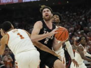 Gonzaga forward Drew Timme (2) drives to the basket against Texas forward Dylan Disu (1) during the first half of an NCAA college basketball game, Wednesday, Nov. 16, 2022, in Austin, Texas.
