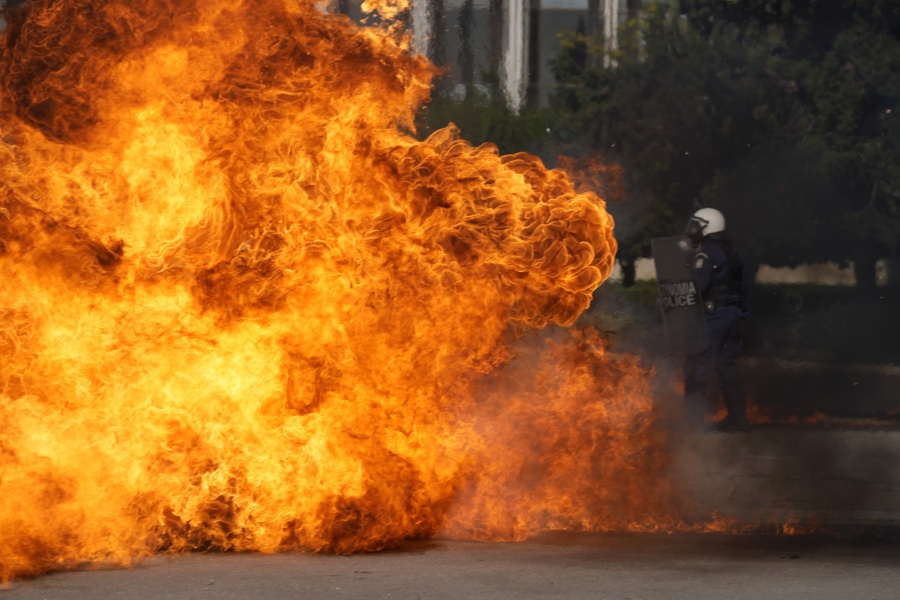 A Molotov cocktail explodes near riot police outside the Greek Parliament during clashes in Athens, Greece, Wednesday, Nov. 9, 2022. Thousands of protesters are marching through the streets of Athens and the northern Greek city of Thessaloniki as public and some private sector workers walk off the job for a 24-hour general strike against price hikes.