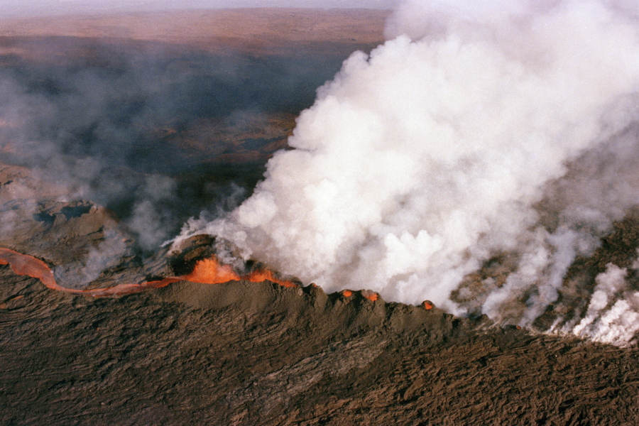 FILE - A gaseous cloud rises from the crater of Mauna Loa, center, on the big island of Hawaii, April 4, 1984. The ground is shaking and swelling at Mauna Loa, the largest active volcano in the world, indicating that it could erupt. Scientists say they don't expect that to happen right away but officials on the Big Island of Hawaii are telling residents to be prepared in case it does erupt soon.