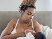 In this photo provided by Mark Godbolt Jr., his wife, Jade Godbolt, nurses her newborn child at their Dallas-area home in October 2022. She and her husband chose a home birth for their third child. Godbolt, 31, says there were no complications and she and her son are doing well. "I believed that my body could do what it was made to do and I wanted to be in the comfort of my home to do that,'' she said. (Mark Godbolt Jr.