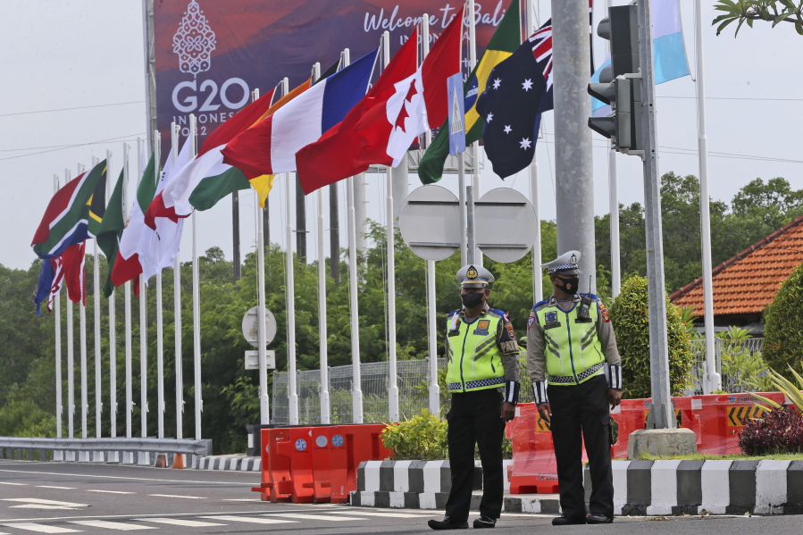 Police officers stand guard as flags of G20 countries wave on a road leading to the venue of the G20 Summit in Nusa Dua, Bali, Indonesia on Saturday, Nov. 12, 2022.