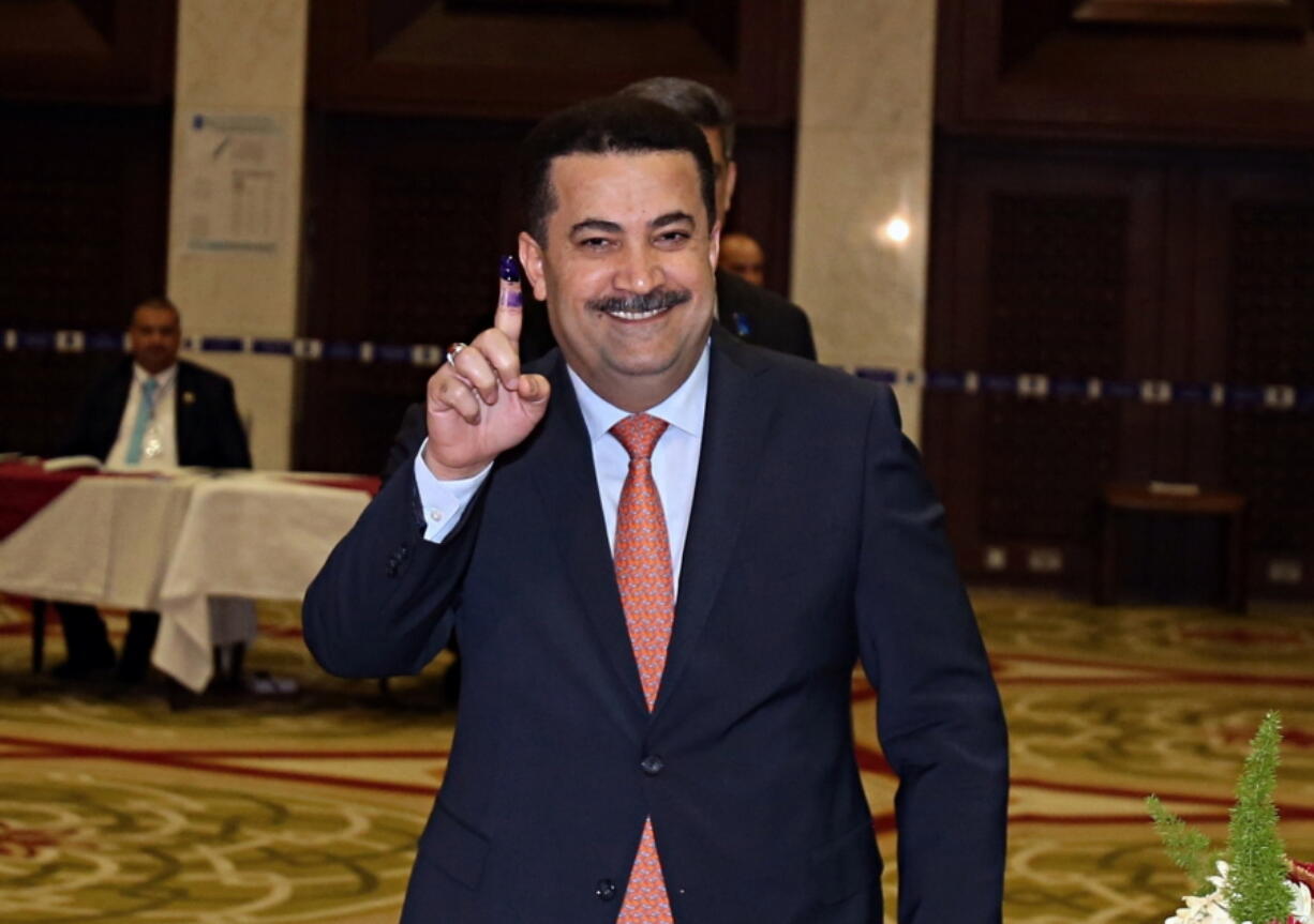 FILE - Mohammed Shias al-Sudani, Minister of Labor and Social Affairs shows his ink-stained finger after casting his vote in the country's parliamentary elections in the heavily fortified Green Zone in Baghdad, Iraq, Saturday, May 12, 2018. Iraq's Prime Minister Mohammed Shia al-Sudani said in a statement on Sunday Nov. 27, 2022, it will recover part of nearly $2.5 billion in funds embezzled from the country's tax authority in a massive scheme involving a network of businesses and officials.