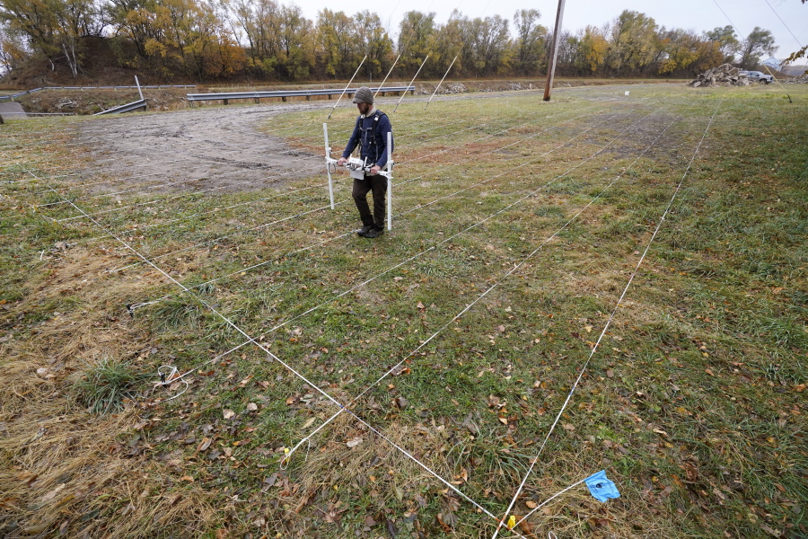 A member of a team affiliated with the National Park Service uses ground-penetrating radar in hopes of detecting what is beneath the soil while searching for over 80 Native American children buried at the former Genoa Indian Industrial School, Thursday, Oct. 27, 2022, in Genoa, Neb. For decades the location of the student cemetery has been a mystery, lost over time after the school closed in 1931 and memories faded of the once-busy campus that sprawled over 640 acres in the tiny community of Genoa.
