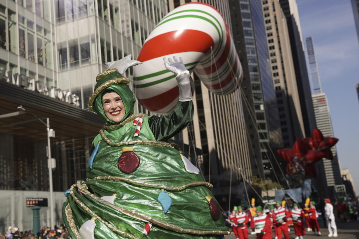 A parade performer in a Christmas Tree costume walks down Sixth Avenue during the Macy's Thanksgiving Day Parade, Thursday, Nov. 24, 2022, in New York.