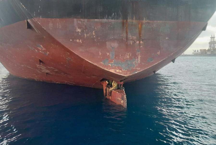 Three men are photographed on an oil tanker anchored in the port of the Canary Islands, Spain. Spain's Maritime Rescue Service says it has rescued three stowaways traveling on a ship's rudder in the Canary Islands. The men were found on the Alithini II oil tanker at the port of Las Palmas.