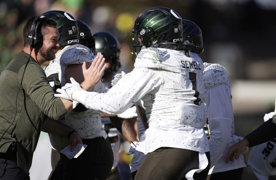 Oregon head coach Dan Lanning, left, congratulates Noah Sewell after he rushed for a 1-yard touchdown against Colorado in the first half of an NCAA college football game, Saturday, Nov. 5, 2022, in Boulder, Colo.