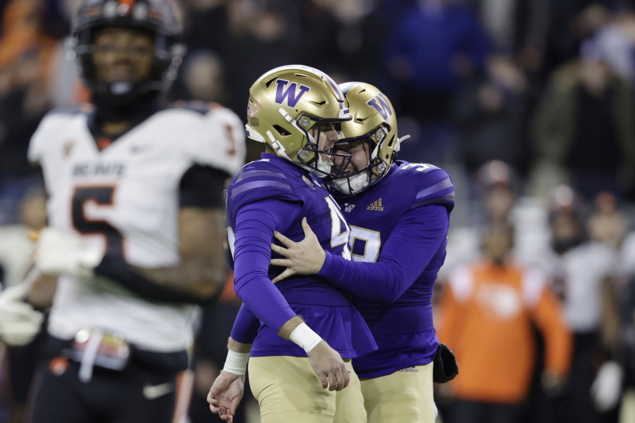Washington placeholder Jack McCallister (38), right, congratulates place kicker Peyton Henry (47) kicking a field goal with eight seconds left on the clock against Oregon State during the second half of an NCAA collage football game, Friday, Nov. 4, 2022, in Seattle. Washington won 24-21.