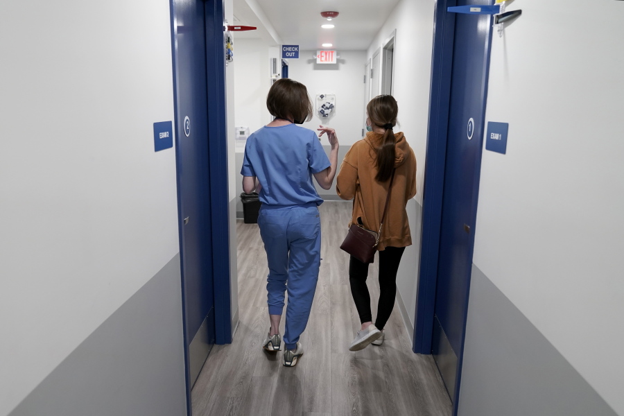 Dr. Elizabeth Brett Daily, left, walks with patient Haley Ruark after providing a medical abortion at a Planned Parenthood clinic Wednesday, Oct. 12, 2022, in Kansas City, Kan.