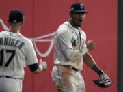 FILE - Seattle Mariners center fielder Julio Rodriguez, right, celebrates after making a catch for an out against the Houston Astros, during the 16 inning in Game 3 of an American League Division Series baseball game Saturday, Oct. 15, 2022, in Seattle. Rodr?guez and Atlanta's Michael Harris II, a pair of 21-year-old center fielders, are baseball's Rookies of the Year.
