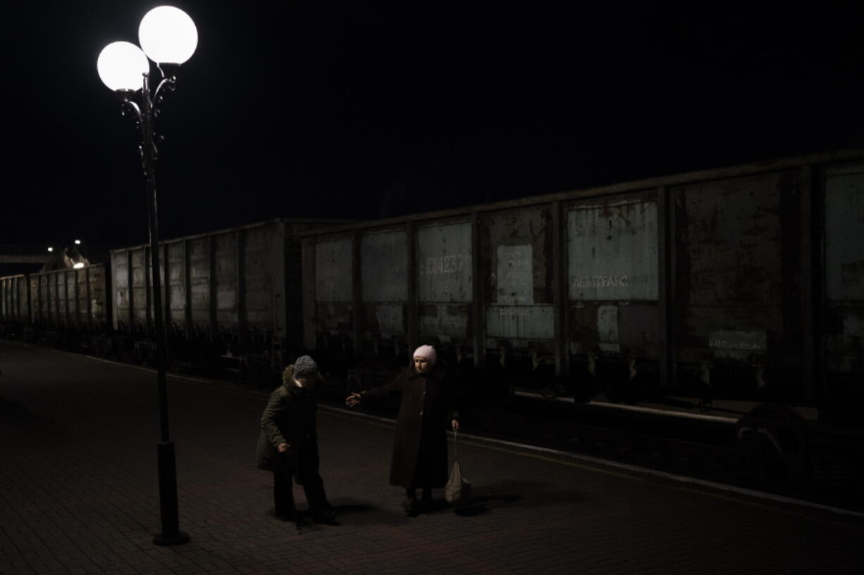 Two elderly Ukrainian women walk towards the Kherson-Kyiv train at the Kherson railway station, southern Ukraine, Monday, Nov. 21, 2022. Ukrainian authorities are evacuating civilians from recently liberated sections of the Kherson and Mykolaiv regions, fearing that a lack of heat, power and water due to Russian shelling will make conditions too unlivable this winter. The move came as rolling blackouts on Monday plagued most of the country.