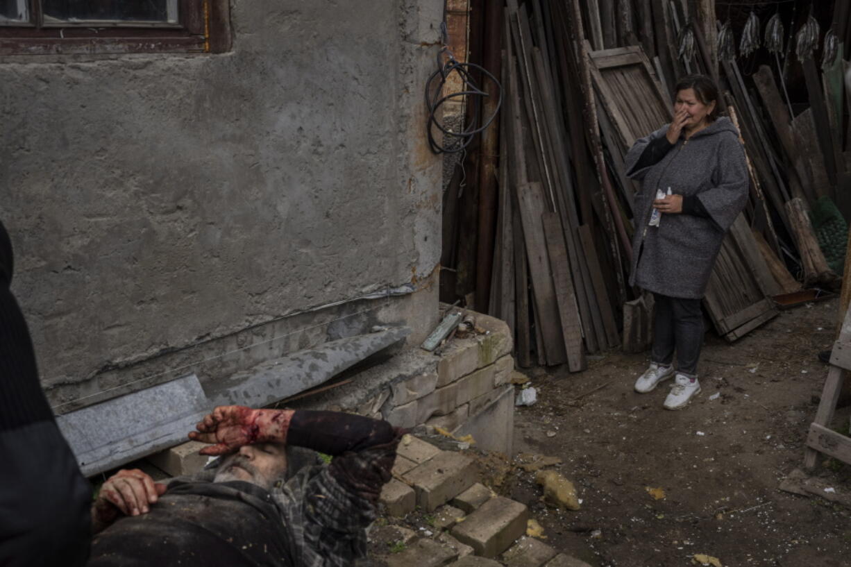 Viktor Anastasiev's wife cries near her wounded husband after a Russian strike in Kherson, southern Ukraine, Thursday, Nov. 24, 2022.