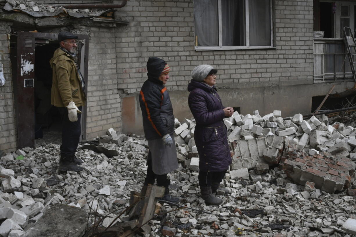 Local residents react near the destroyed house after recent Russian air strike in Chasiv Yar, Ukraine, Sunday, Nov. 27, 2022. Shelling by Russian forces struck several areas in eastern and southern Ukraine overnight as utility crews continued a scramble to restore power, water and heating following widespread strikes in recent weeks, officials said Sunday.