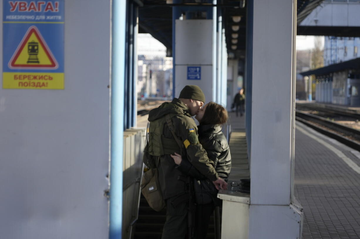 A couple kiss as they stand on a platform at the train station in Kyiv, Ukraine, Sunday Nov. 13, 2022. The rail service has had some 300 workers killed and 600 wounded in the nearly nine-month Russian invasion and the network has suffered thousands of attacks but says it still managed to run 85% of its trains on schedule last month.