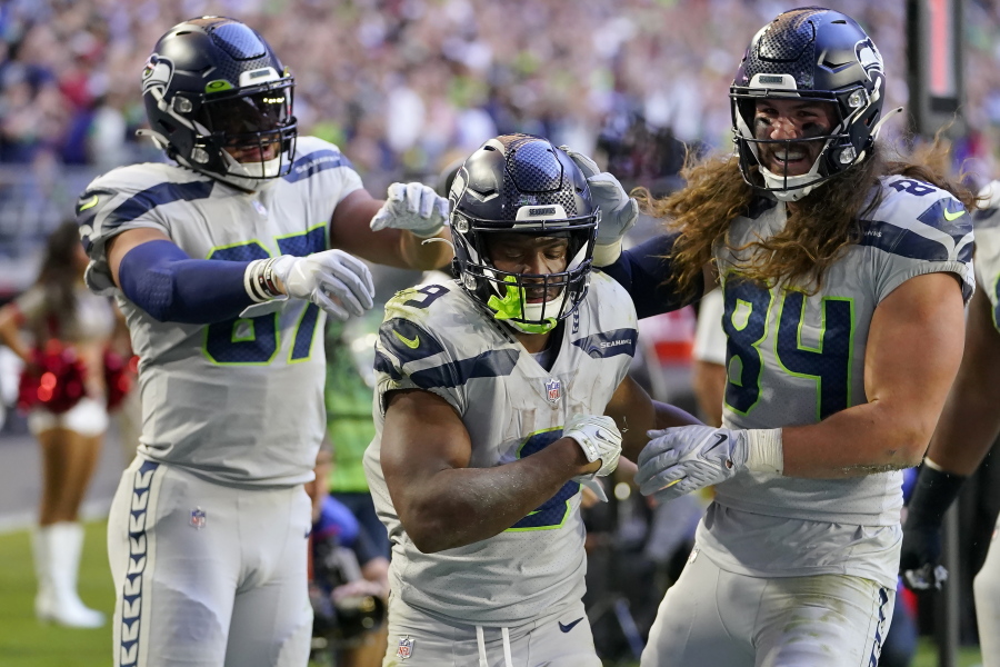 Seattle Seahawks running back Kenneth Walker III, middle, is congratulated by tight end Noah Fant, left, and tight end Colby Parkinson (84) after scoring against the Arizona Cardinals during the second half Sundayin Glendale, Ariz., Sunday.