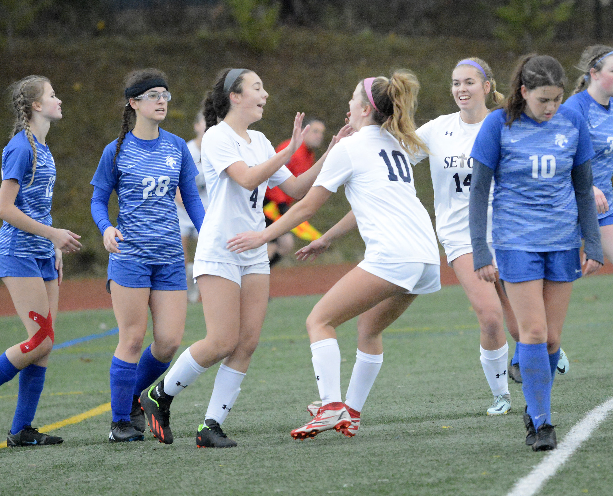 Seton Catholic's Camryn Moore (4) is congratulated by teammate Anna Mooney (10) after Moore scored a goal during the 1A girls soccer district third-place match at King's Way Christian High School on Saturday, Nov. 5, 2022.