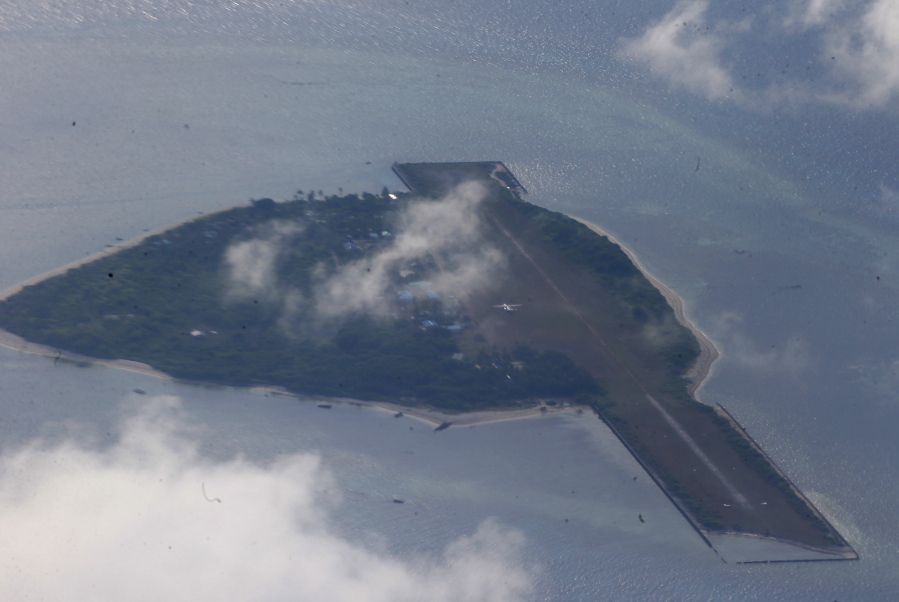 FILE - This photo taken from a C-130 transport plane with Defense Chief Delfin Lorenzana and Armed Forces Chief Gen. Eduardo Ano shows Thitu Island off the South China Sea on April 21, 2017. A Chinese coast guard vessel twice blocked the Philippine naval boat before seizing the debris it was towing Sunday off Philippine-occupied Thitu Island, Vice Admiral Alberto Carlos said Monday., Nov. 21, 2022.