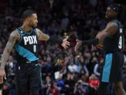 Portland Trail Blazers guard Damian Lillard, left, and forward Jerami Grant celebrate at the end of the team's NBA basketball game against the San Antonio Spurs in Portland, Ore., Tuesday, Nov. 15, 2022.