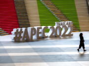 A participant runs past signage at the venue of the Asia-Pacific Economic Cooperation APEC summit venue, Friday, Nov. 18, 2022, in Bangkok, Thailand.