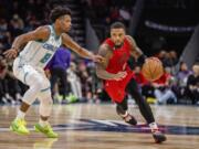 Charlotte Hornets guard Dennis Smith Jr. (8) guards Portland Trail Blazers guard Damian Lillard (0) during the second half of an NBA basketball game Wednesday, Nov. 9, 2022, in Charlotte, N.C.
