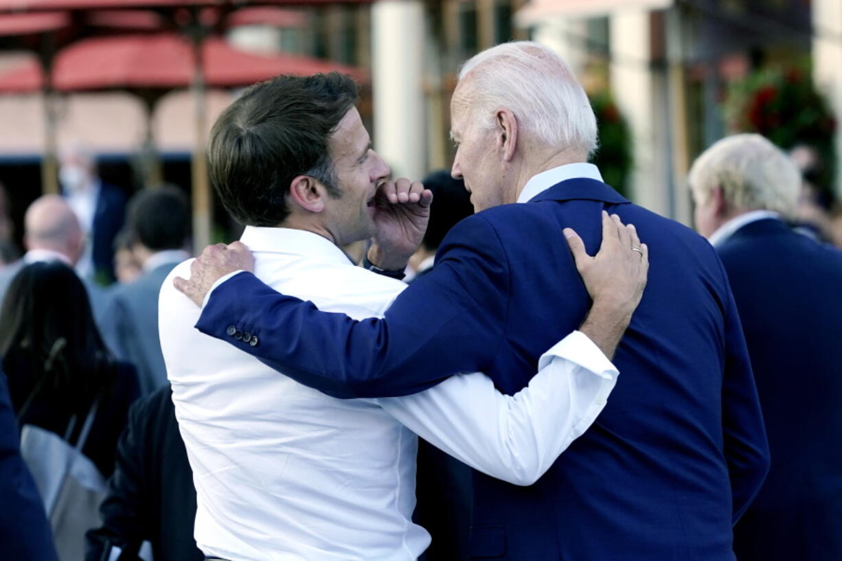 FILE - French President Emmanuel Macron whispers to U.S. President Joe Biden following their dinner at the G7 Summit in Elmau, Germany, June 26, 2022. Macron is heading to Washington for the first state visit of Biden's presidency--a reviving of diplomatic pageantry that had been put on hold because of the COVID-19 pandemic.