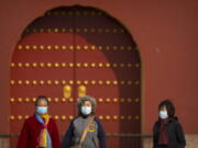 People wearing face masks walk at the Temple of Heaven in Beijing, Saturday, Nov. 12, 2022. Everyone in a district of 1.8 million people in China's southern metropolis of Guangzhou was ordered to stay home Saturday to undergo virus testing and a major city in the southwest closed schools as another rise in infections was reported.