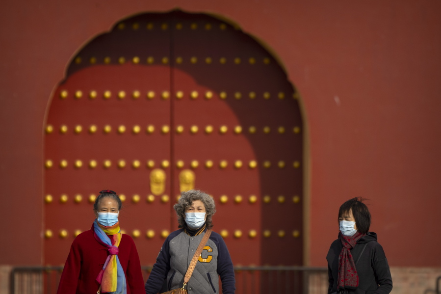 People wearing face masks walk at the Temple of Heaven in Beijing, Saturday, Nov. 12, 2022. Everyone in a district of 1.8 million people in China's southern metropolis of Guangzhou was ordered to stay home Saturday to undergo virus testing and a major city in the southwest closed schools as another rise in infections was reported.