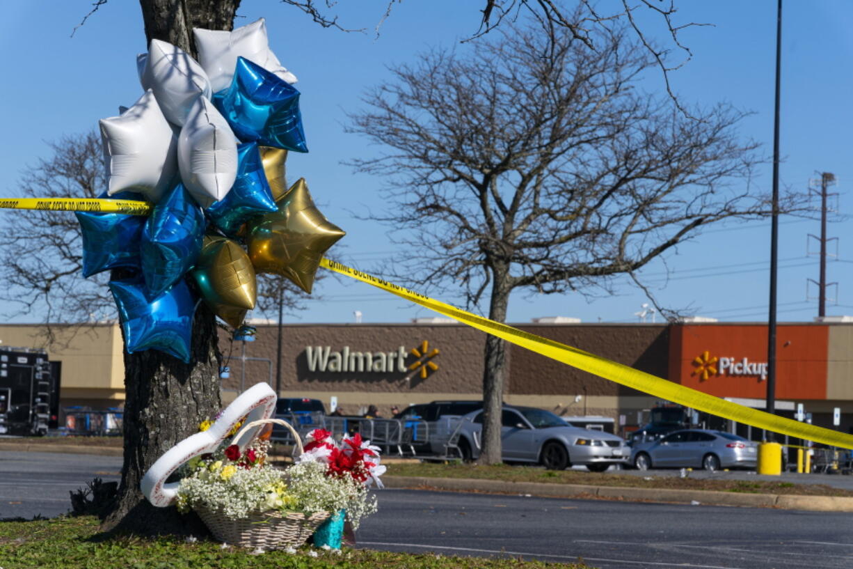 Flowers and balloons have been placed near the scene of a mass shooting at a Walmart, Wednesday, Nov. 23, 2022, in Chesapeake, Va. A Walmart manager opened fire on fellow employees in the break room of the Virginia store, killing several people in the country's second high-profile mass shooting in four days, police and witnesses said Wednesday.
