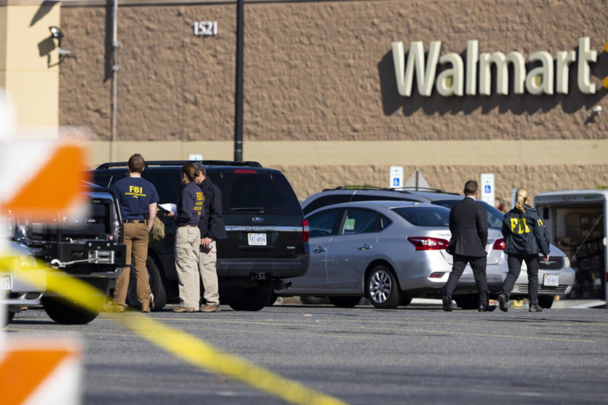 Law enforcement, including the FBI, work at the scene of a mass shooting at a Walmart, Wednesday, Nov. 23, 2022, in Chesapeake, Va. A Walmart manager opened fire on fellow employees in the break room of the Virginia store, killing several people in the country's second high-profile mass shooting in four days, police and witnesses said Wednesday.