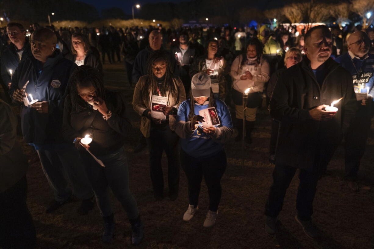 Community members, including Walmart employees, gather for a candlelight vigil at Chesapeake City Park in Chesapeake, Va., Monday, Nov. 28, 2022, for the six people killed at a Walmart in Chesapeake, Va., when a manager opened fire with a handgun before an employee meeting last week.