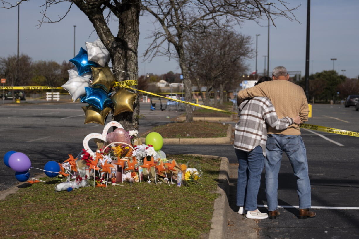 Debbie, left, and Chet Barnett place flowers at a memorial outside of the Chesapeake, Va., Walmart on Thursday, Nov. 24, 2022.  Andre Bing, a Walmart manager, opened fire on fellow employees in the break room of the Virginia store, killing six people in the country's second high-profile mass shooting in four days, police and witnesses said Wednesday.