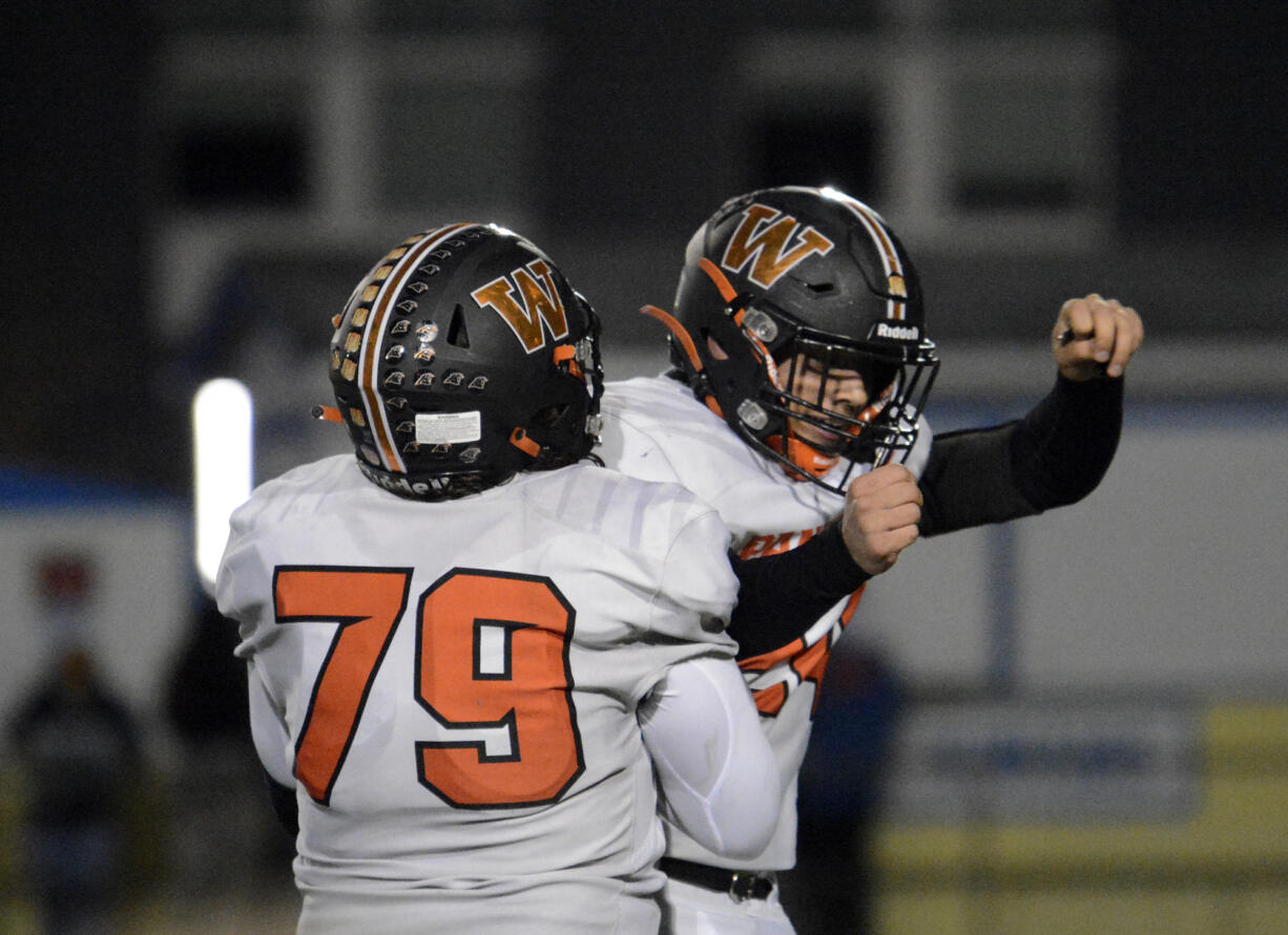 Washougal's William Cooper celebrates with teammate Jose Alvarez-Cruze (79) after Cooper returned an interception for a touchdown in a 30-27 state playoff loss to Highline in Burien on Friday, Nov. 11, 2022.