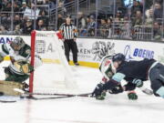 Minnesota Wild goalie Marc-Andre Fleury, left, knocks away a shot by Seattle Kraken forward Ryan Donato, right, during the second period of an NHL hockey game Friday, Nov. 11, 2022, in Seattle.