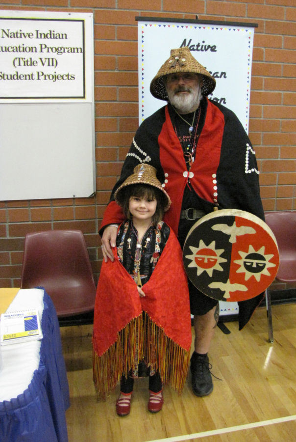 Seven-year-old Destany Reeves-Robinson and her grandfather, Sam Robinson, pause between dances at a traditional Native American Pow-Wow at Covington Middle School in 2012.