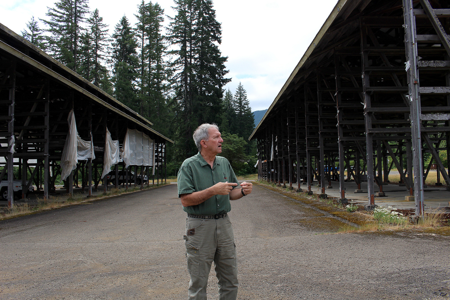 Skamania County Commissioner Bob Hamlin stands in front of derelict buildings as he talks about future development plans.
