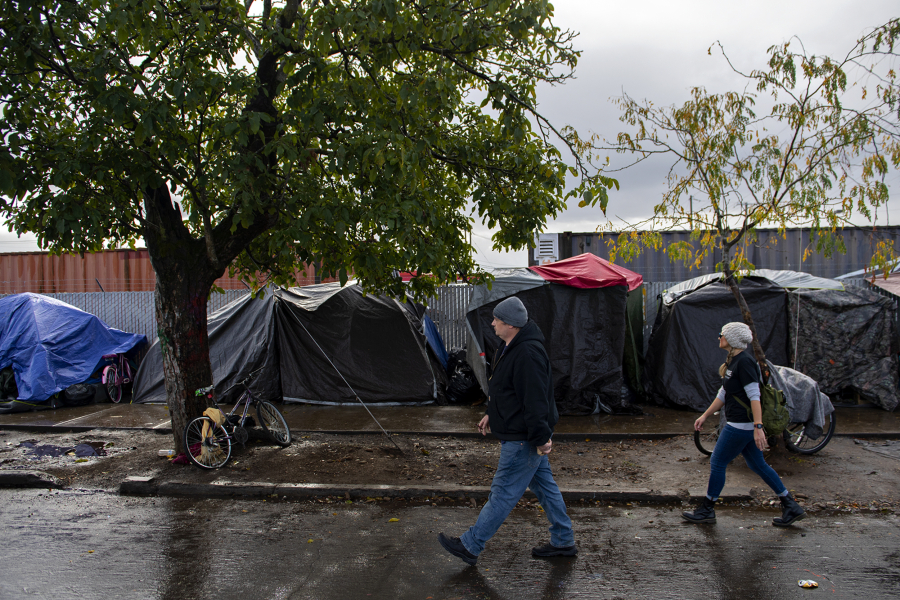 Jacob Phillips, left, and Tiffany Mercer of XChange's Street Medicine Team stroll past tents to offer medical assistance to those living near the Share House on a Wednesday morning in October.