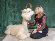 Farm co-owner Shannon Joy, right, readies for a "carrot kiss" from 12-year-old therapy alpaca Jean-Pierre. Getting a kiss from the farm's alpacas and llamas is the highlight for many visitors.