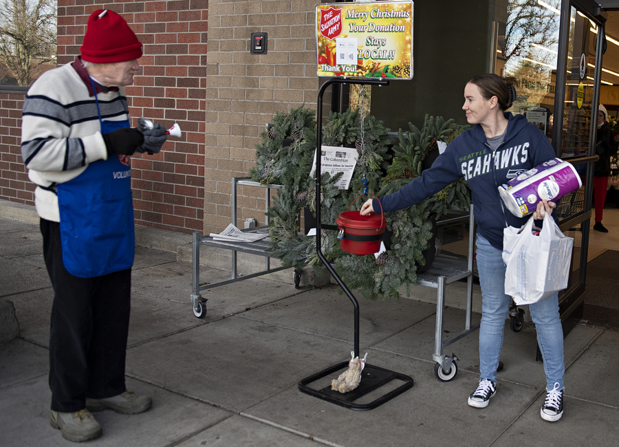 Volunteer Ed Kahler greets shopper Sherrie McNabb of Vancouver as she donates to The Salvation Army at the Four Seasons Safeway on Thursday afternoon. At top, "I think the sound of the bell cheers people up," said Kahler, a three-year volunteer for The Salvation Army.